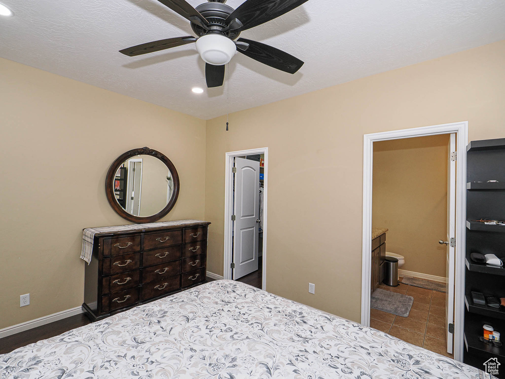 Bedroom featuring recessed lighting, baseboards, ceiling fan, ensuite bathroom, and a walk in closet