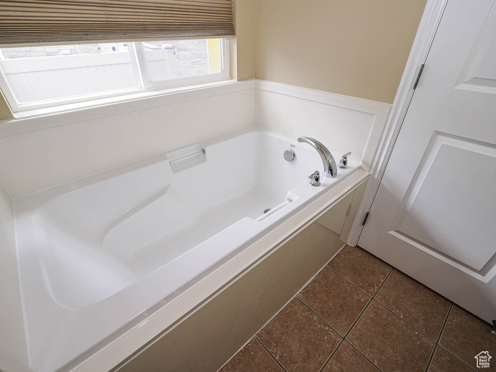 Bathroom featuring tile patterned flooring and a garden tub