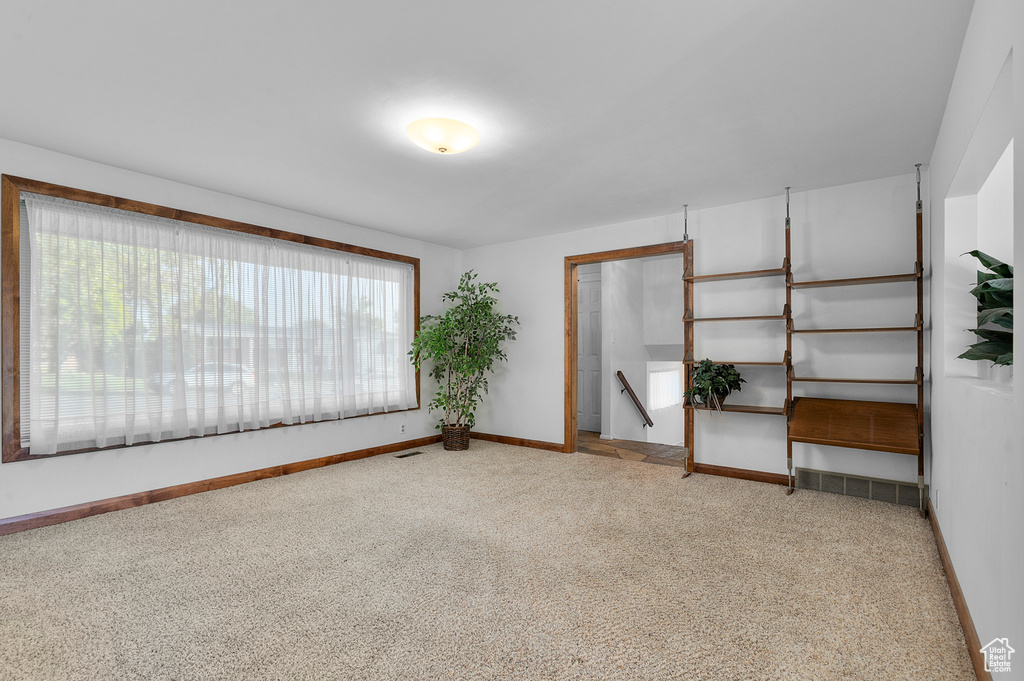 Carpeted empty room featuring baseboards