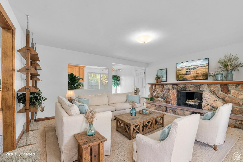 Living area featuring light colored carpet and a fireplace