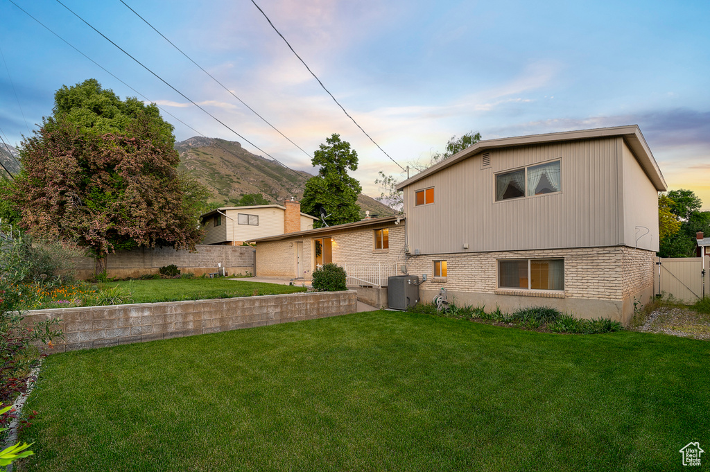 Back of house with brick siding, central air condition unit, and a mountain view