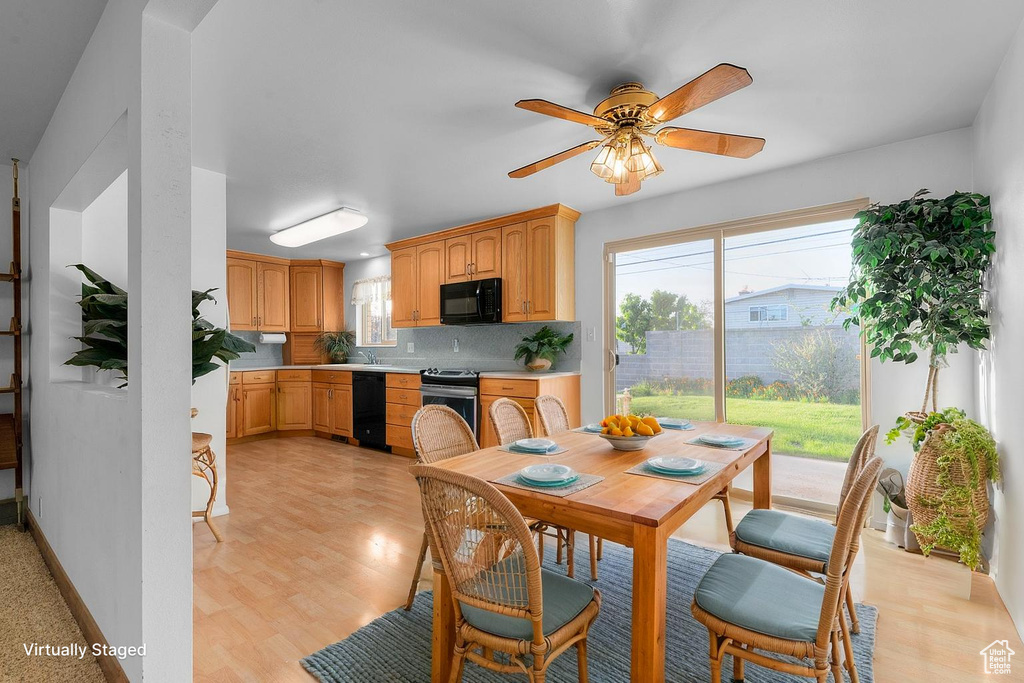 Dining area with a ceiling fan and light wood-type flooring