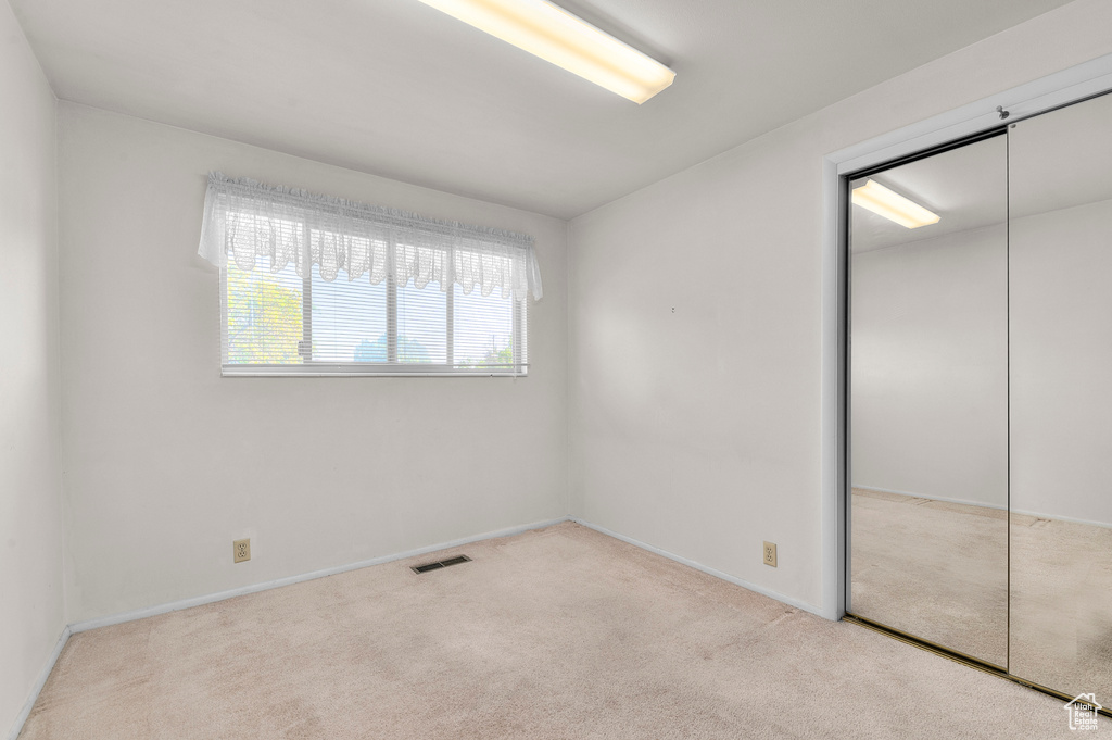 Unfurnished bedroom featuring carpet, a closet, and baseboards