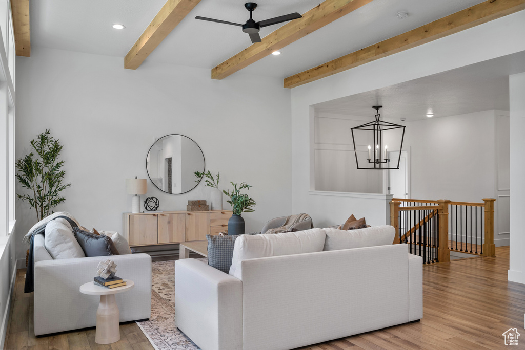 Living area featuring recessed lighting, beamed ceiling, light wood-type flooring, a chandelier, and ceiling fan