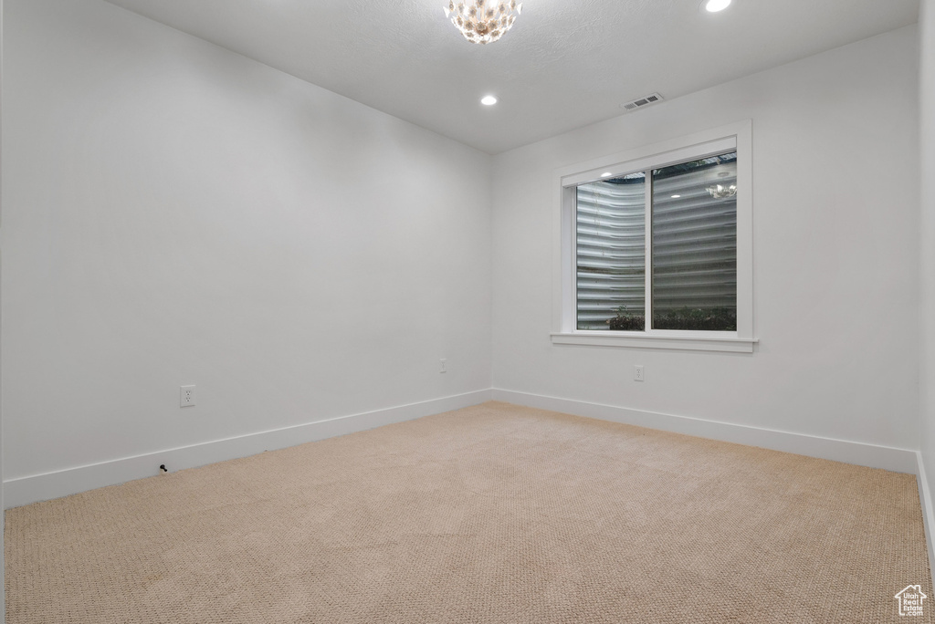 Spare room featuring light carpet, recessed lighting, and baseboards