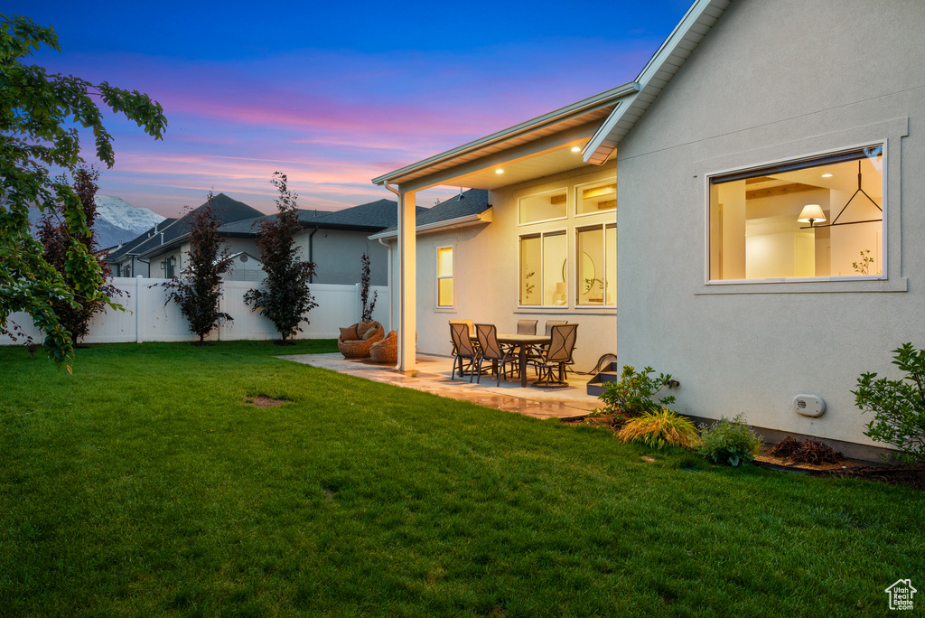 Yard at dusk featuring a patio area