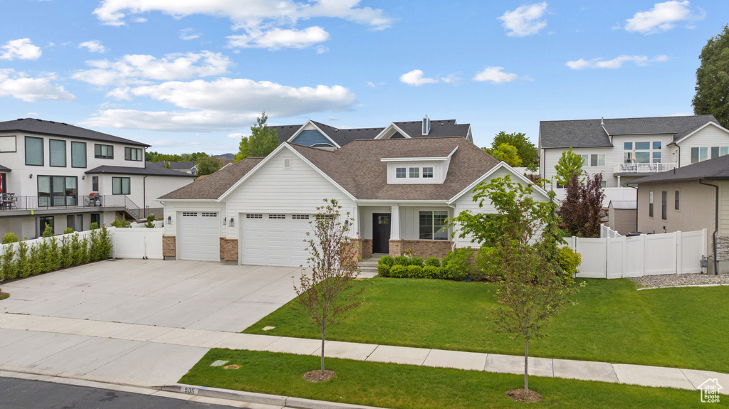 View of front of house featuring a garage, driveway, a residential view, and a shingled roof