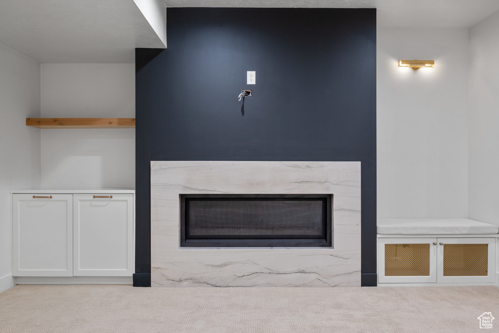 Unfurnished living room featuring a high end fireplace and carpet floors