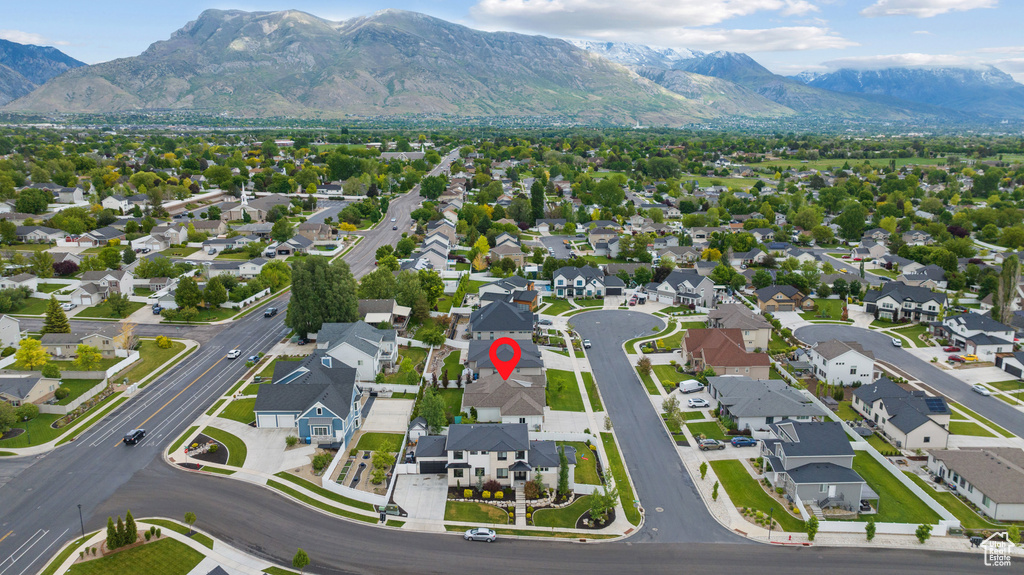 Aerial view of property and surrounding area with a mountainous background and nearby suburban area