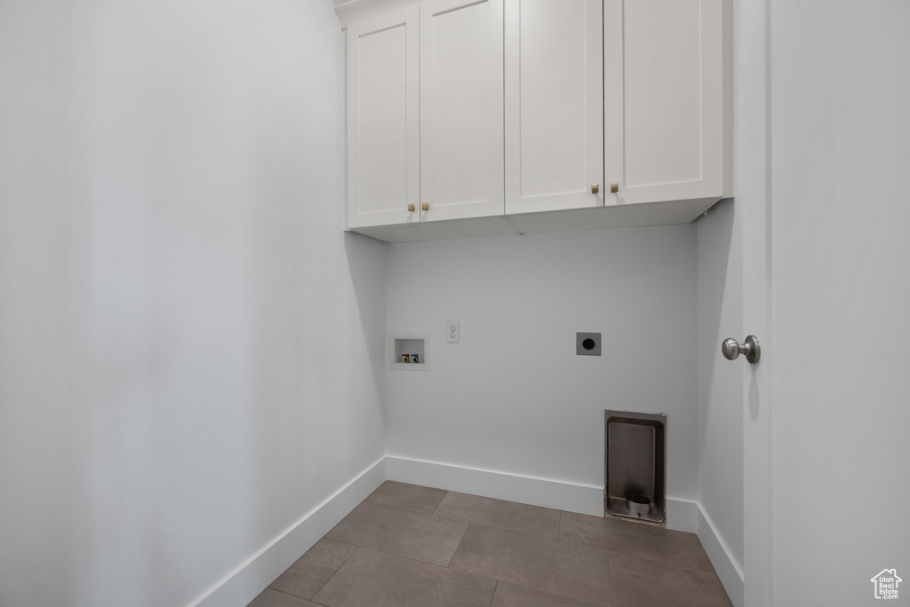 Clothes washing area with cabinet space, electric dryer hookup, baseboards, and hookup for a washing machine