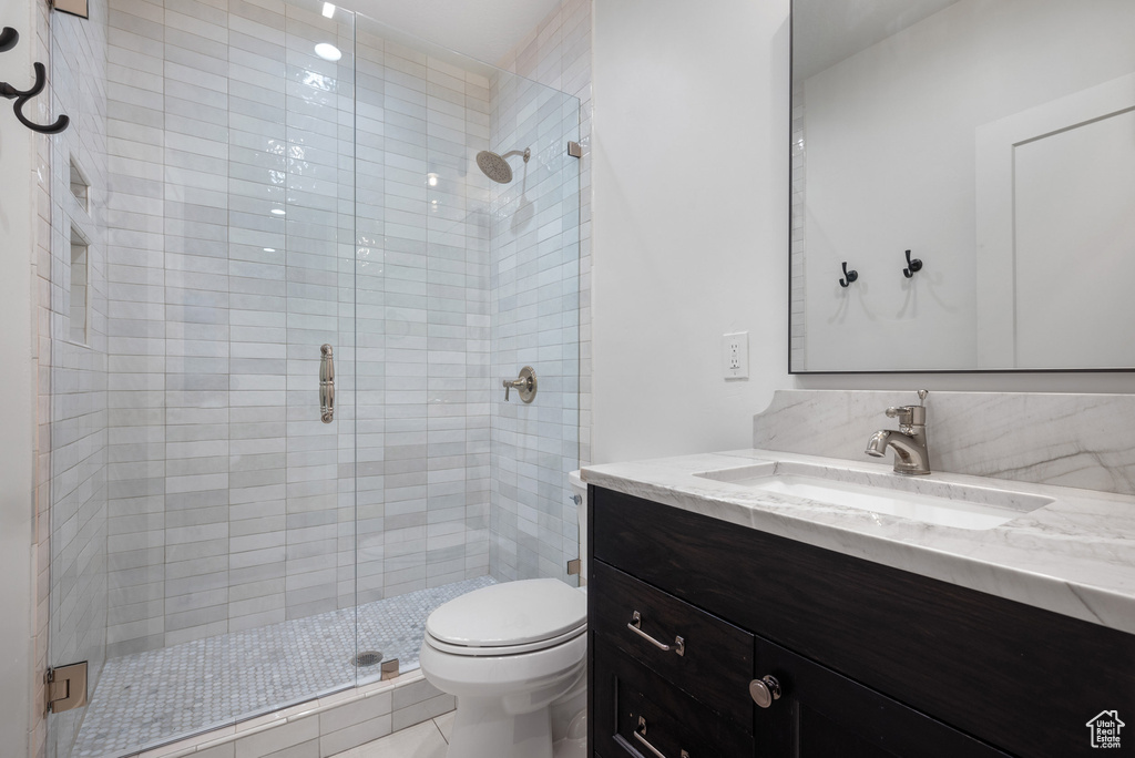 Full bathroom featuring toilet, a shower stall, and vanity