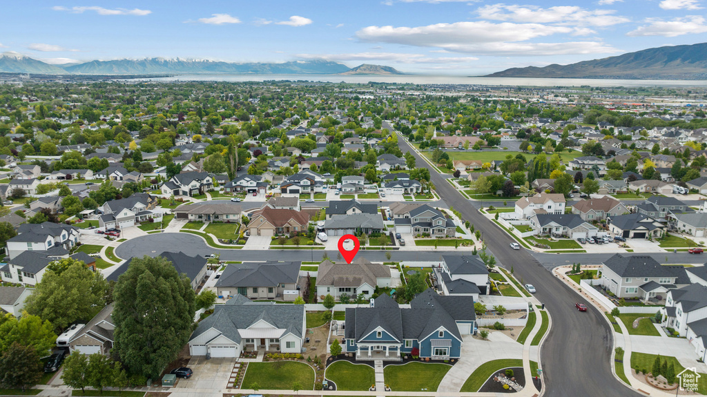 Aerial view of property and surrounding area with a mountainous background and nearby suburban area