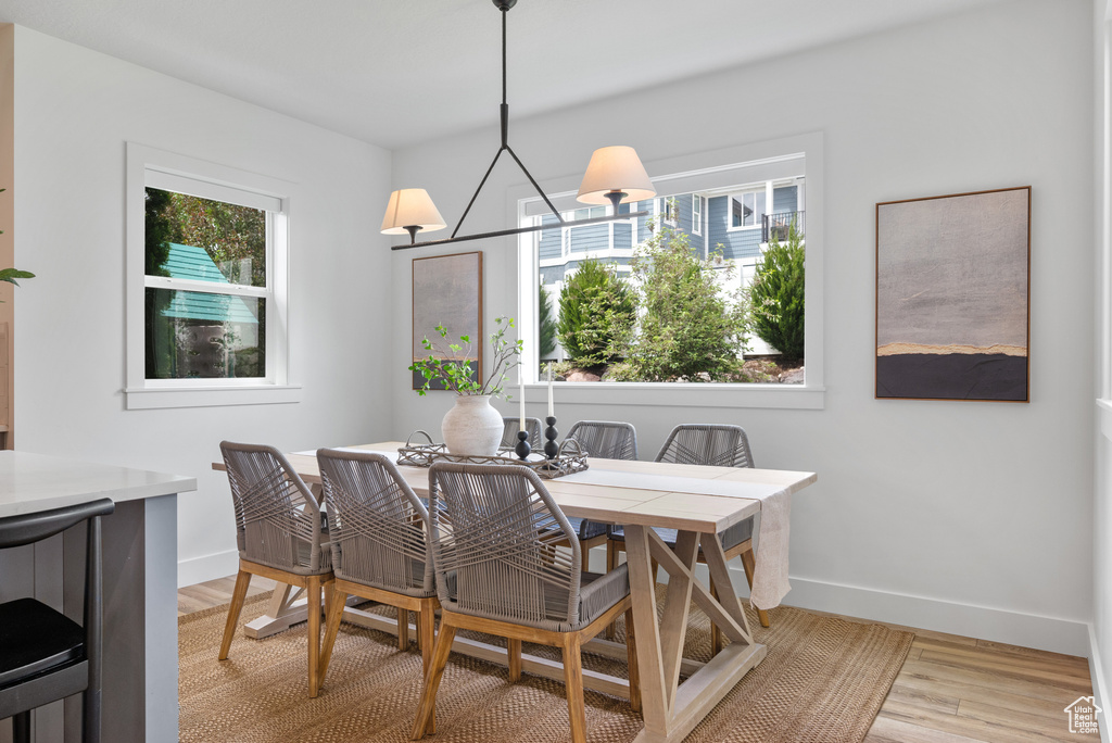 Dining area with plenty of natural light, baseboards, and light wood finished floors