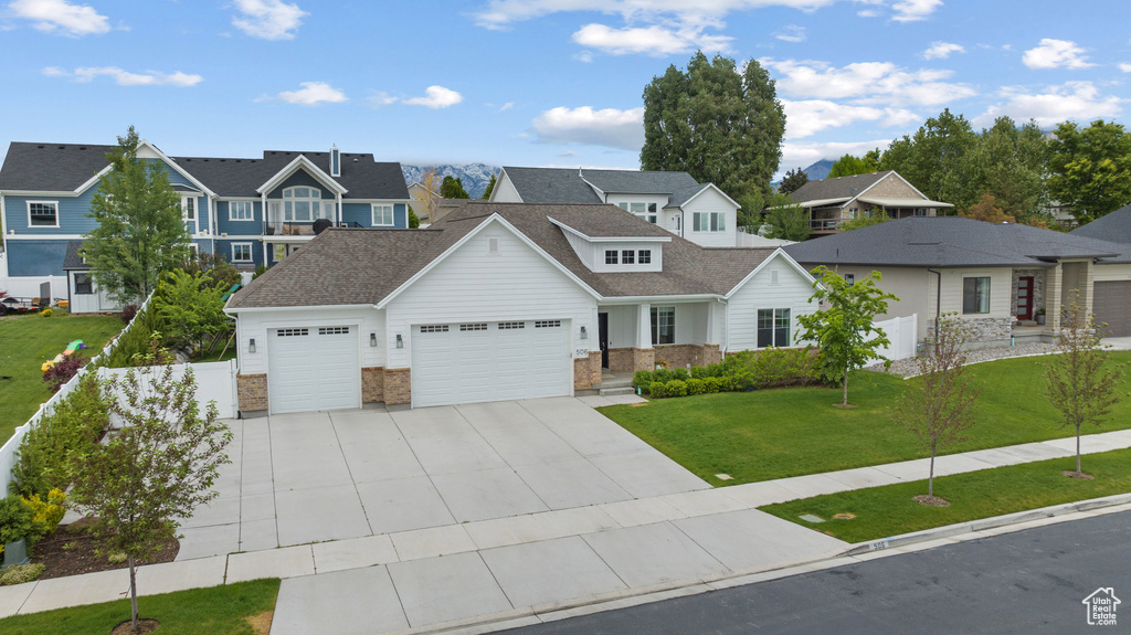 View of front of property featuring a garage, a residential view, concrete driveway, and a shingled roof