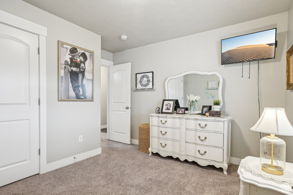 Bedroom featuring light colored carpet and baseboards