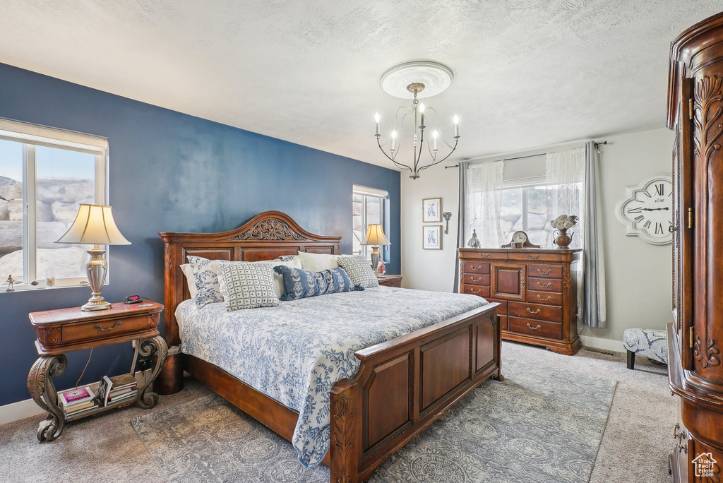 Bedroom featuring carpet and a chandelier