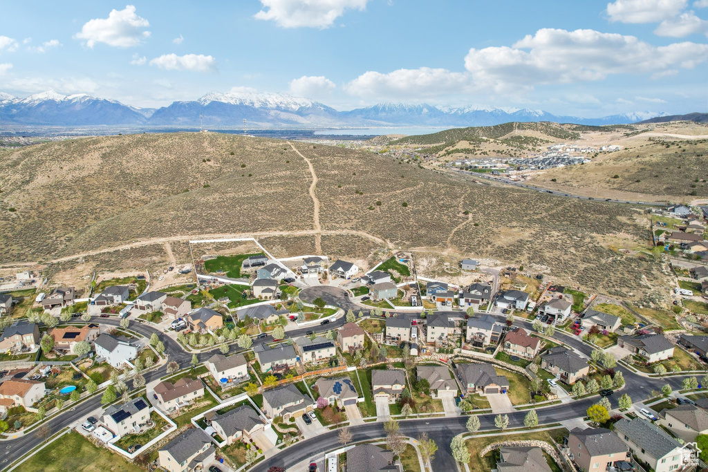 Aerial view of property and surrounding area featuring mountains and nearby suburban area