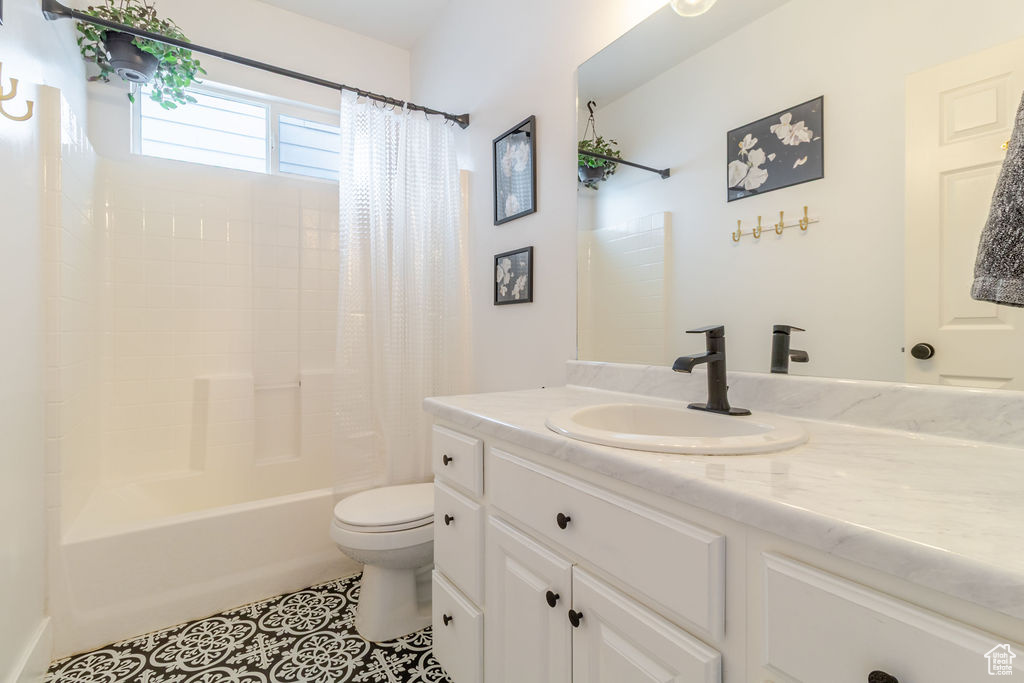 Bathroom with toilet, tile patterned flooring, vanity, and shower / bath combo