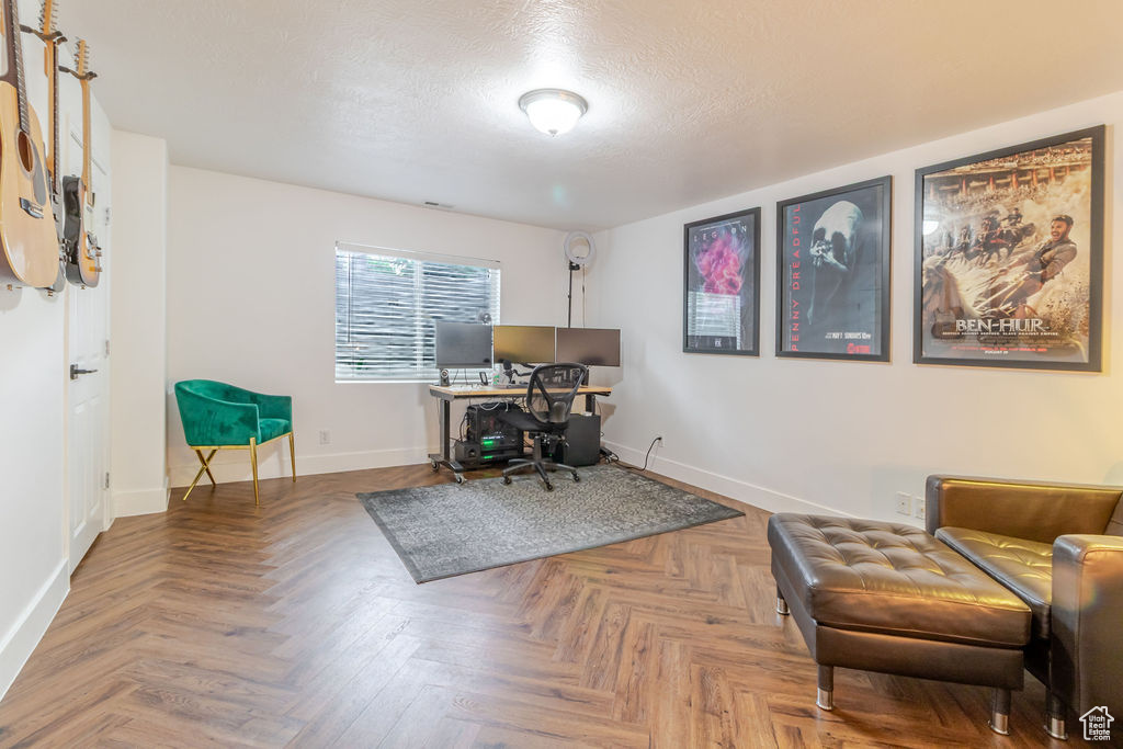 Office area featuring baseboards and a textured ceiling