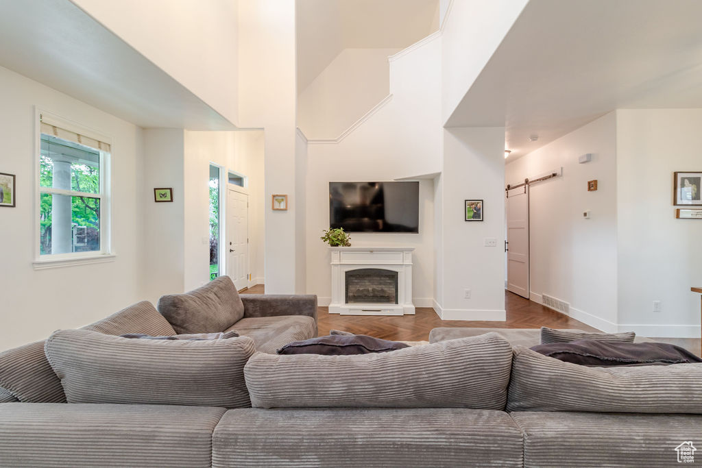 Living area with a barn door, baseboards, and a fireplace with raised hearth