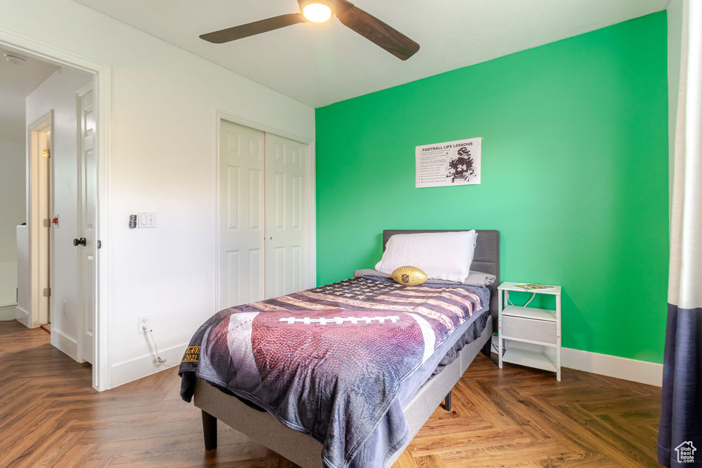 Bedroom featuring a closet, baseboards, a ceiling fan, and an accent wall