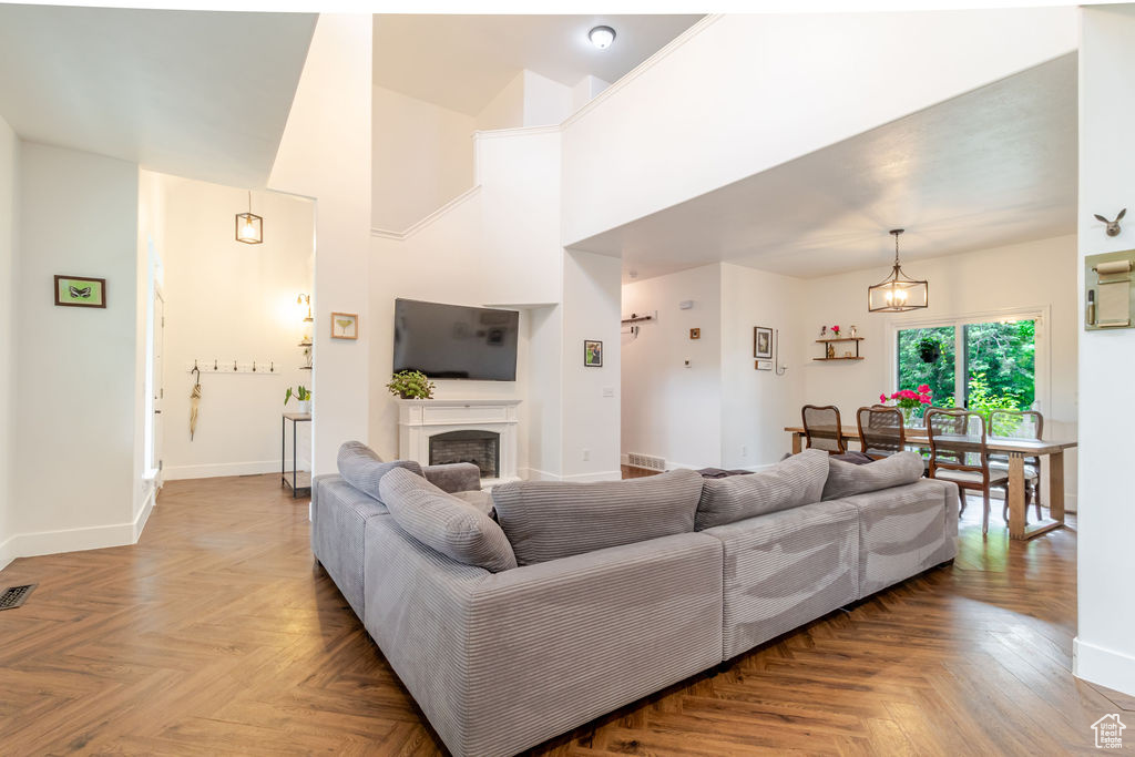 Living area featuring baseboards, a fireplace, and a towering ceiling