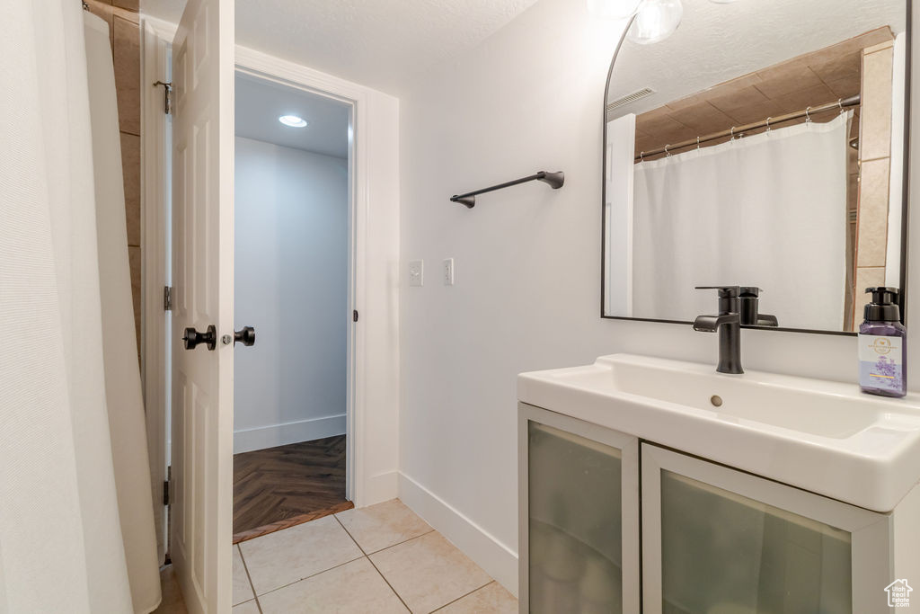 Bathroom featuring baseboards, vanity, and recessed lighting