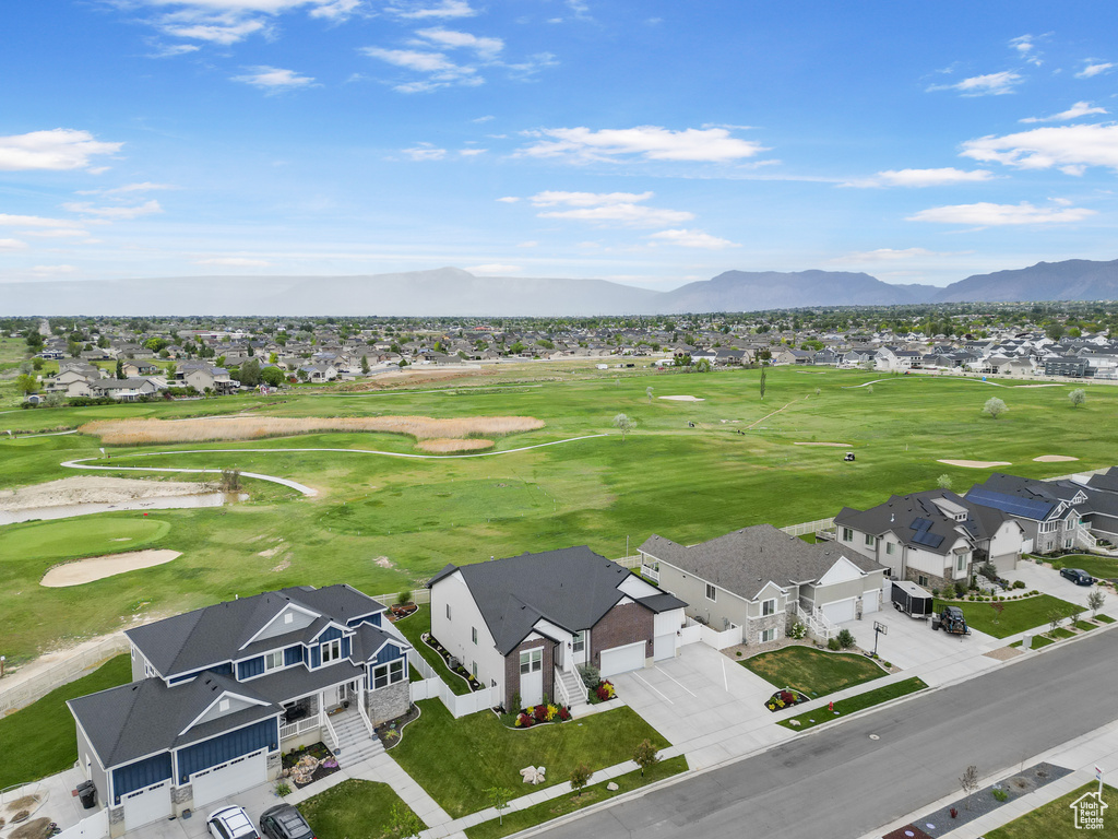 Aerial perspective of suburban area with mountains and a golf club