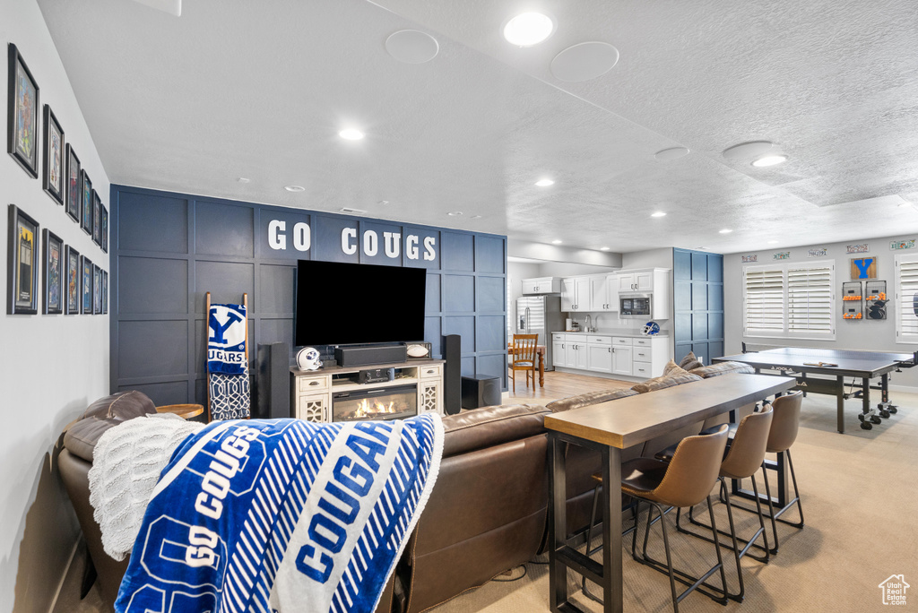Living room with recessed lighting, light carpet, and a textured ceiling