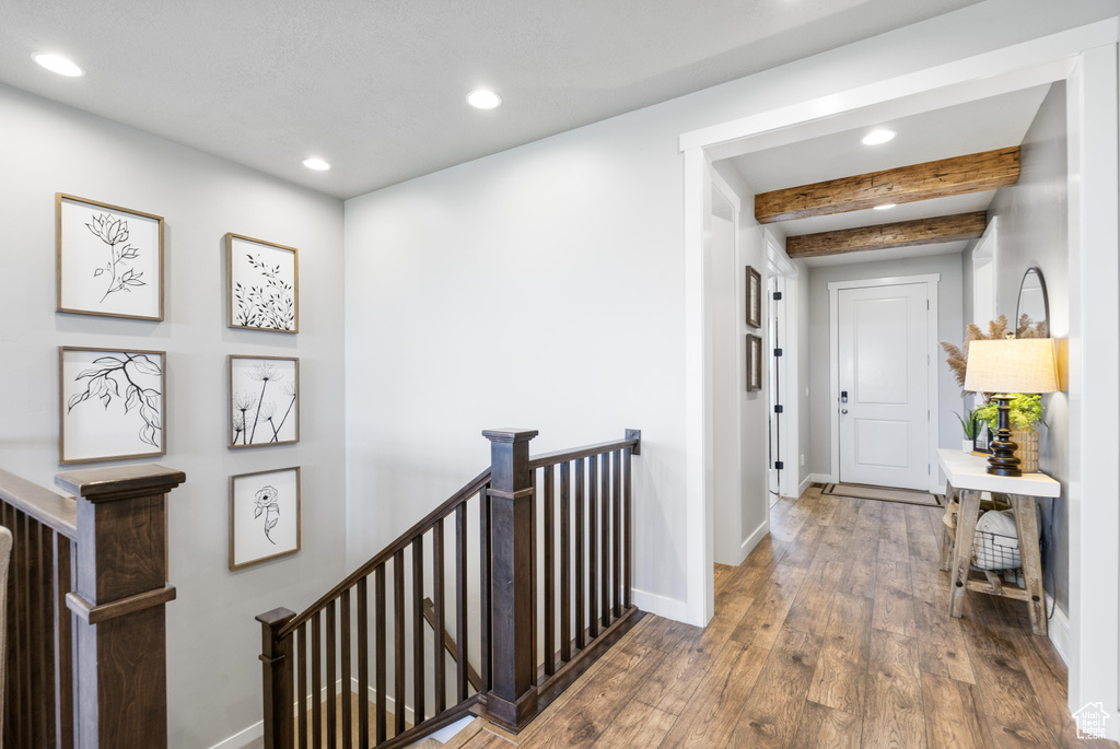 Corridor featuring an upstairs landing, recessed lighting, beam ceiling, baseboards, and hardwood / wood-style floors