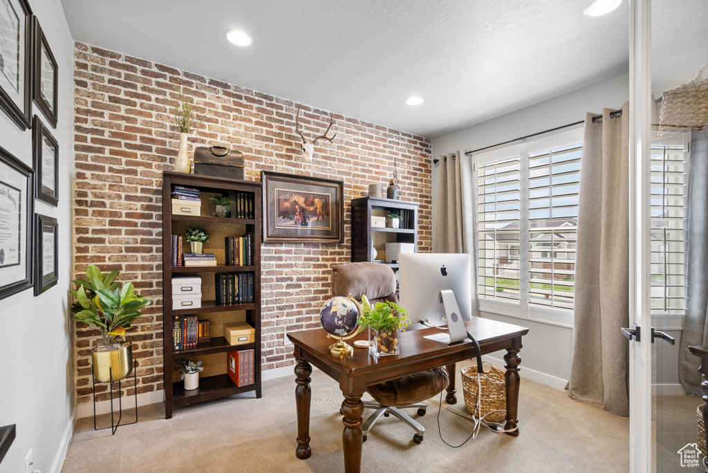 Office area featuring light carpet, brick wall, baseboards, and recessed lighting