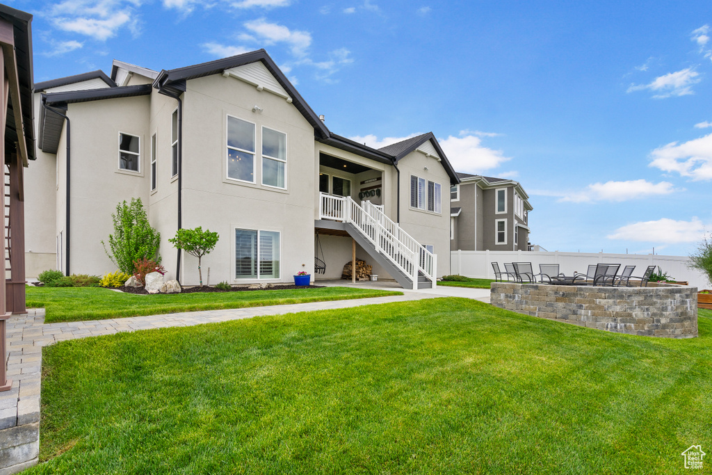 Rear view of property with stairway and stucco siding