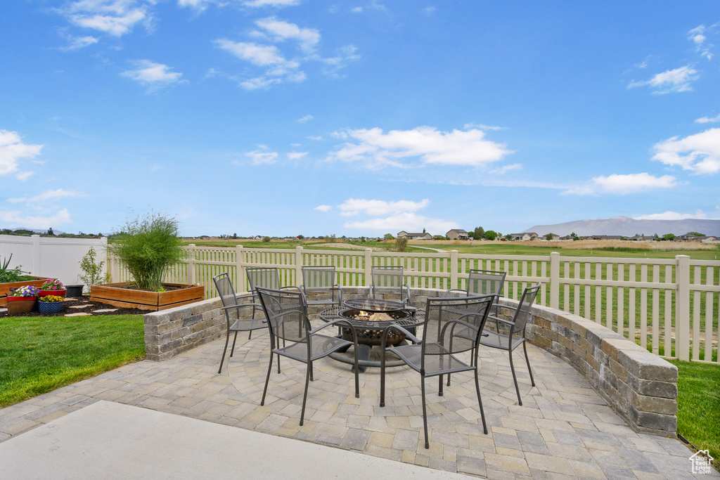View of patio featuring a fire pit and fence