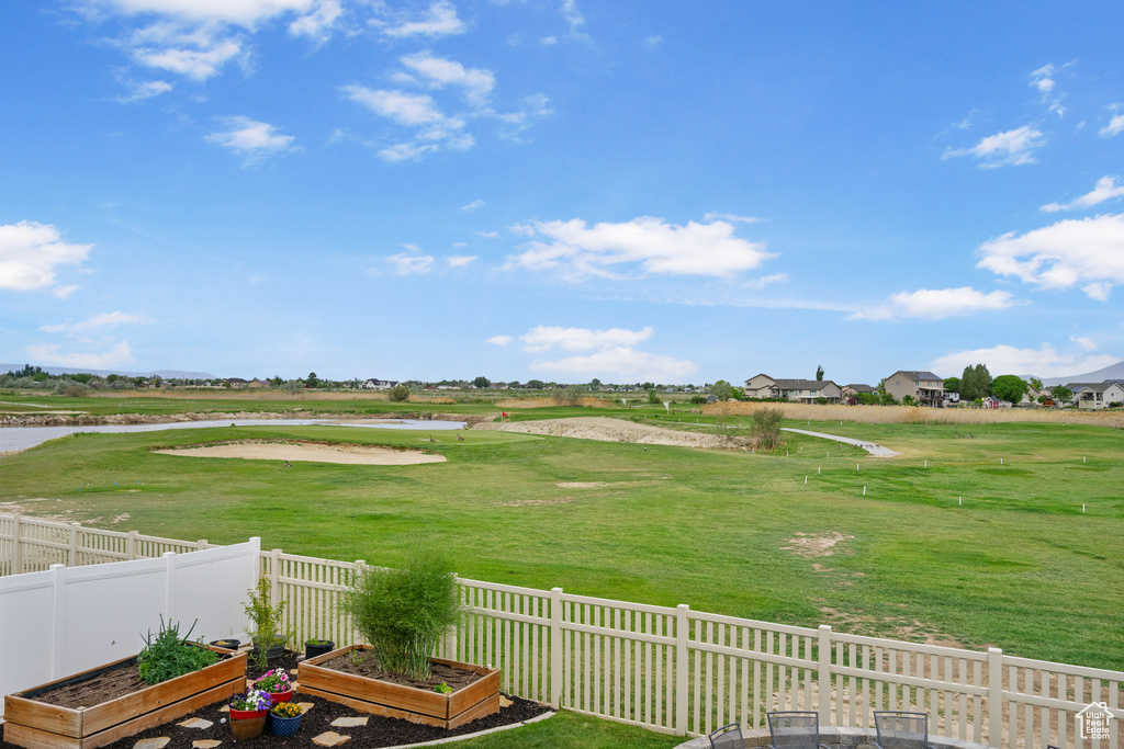 View of yard with a garden, a water view, and view of golf course