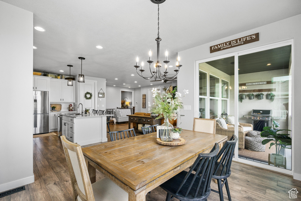 Dining space featuring a chandelier, dark wood finished floors, recessed lighting, and baseboards