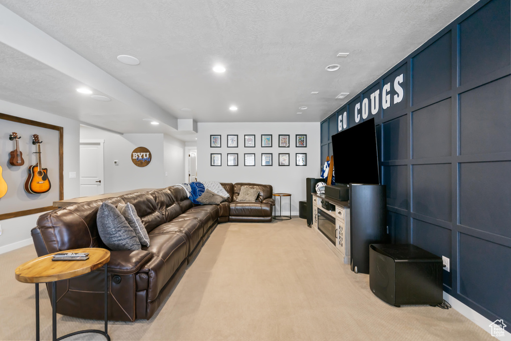 Living area with light carpet, recessed lighting, and baseboards