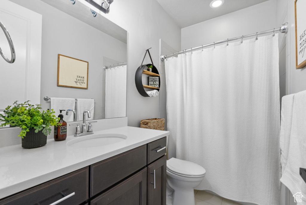 Bathroom with toilet, vanity, tile patterned floors, curtained shower, and recessed lighting