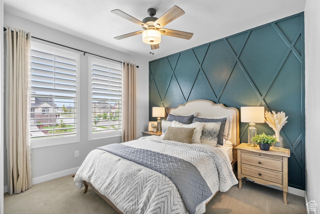 Carpeted bedroom with baseboards and a ceiling fan