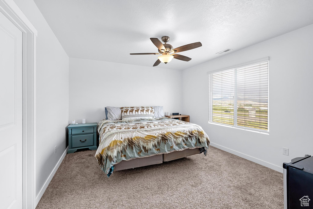 Carpeted bedroom with baseboards and ceiling fan