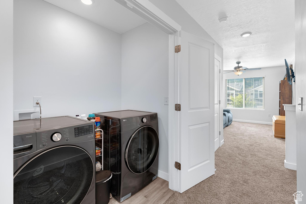 Laundry room with separate washer and dryer, baseboards, carpet flooring, a textured ceiling, and ceiling fan