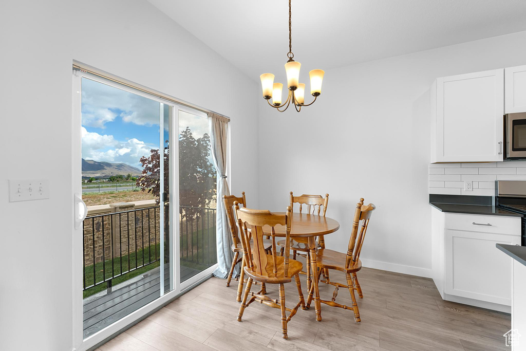 Dining room featuring a chandelier, light wood-type flooring, and baseboards