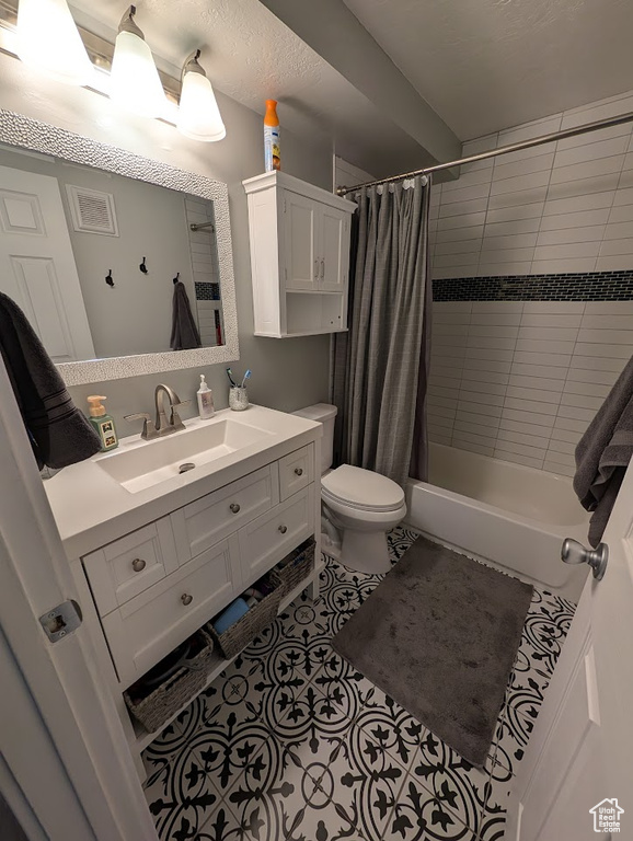 Full bathroom featuring toilet, shower / bath combination with curtain, tile patterned flooring, and vanity