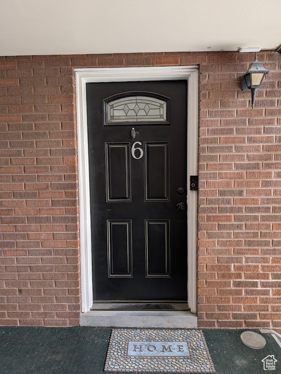 Entrance to property featuring brick siding