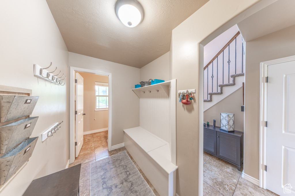 Mudroom featuring tile patterned floors and baseboards