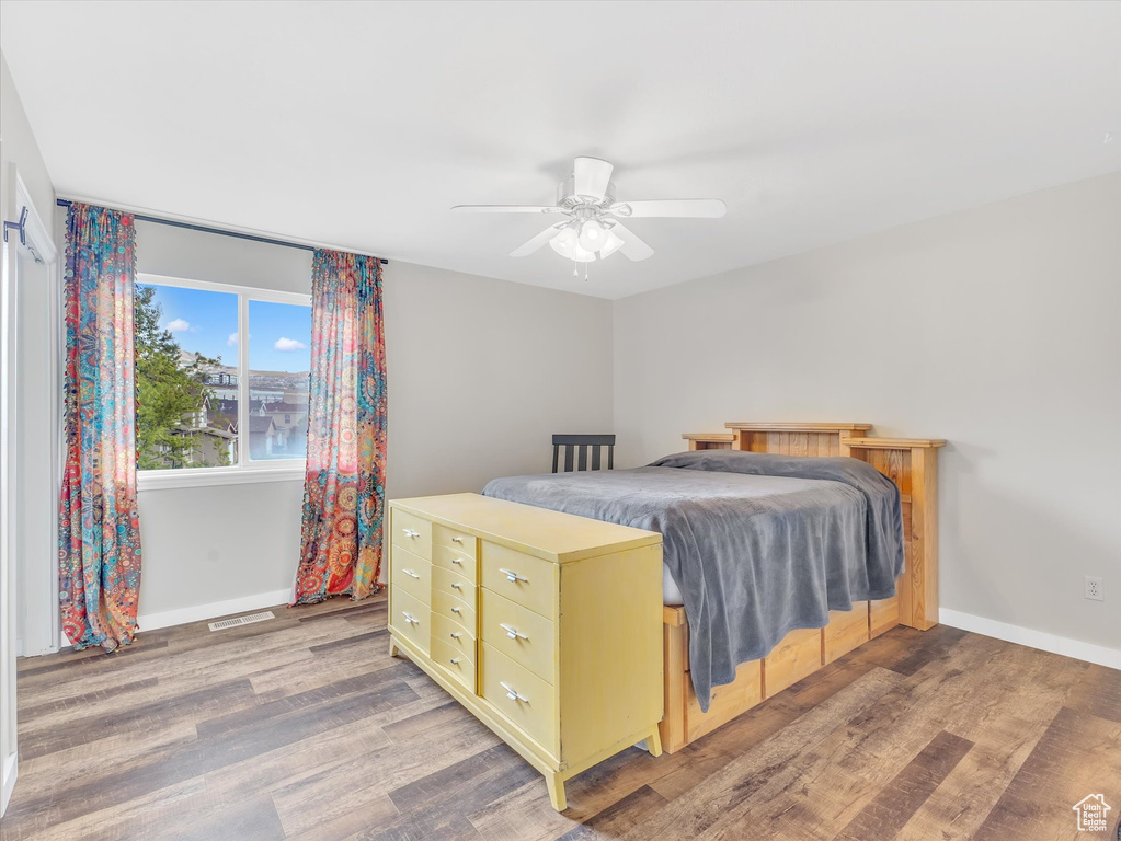 Bedroom featuring wood finished floors, baseboards, and ceiling fan
