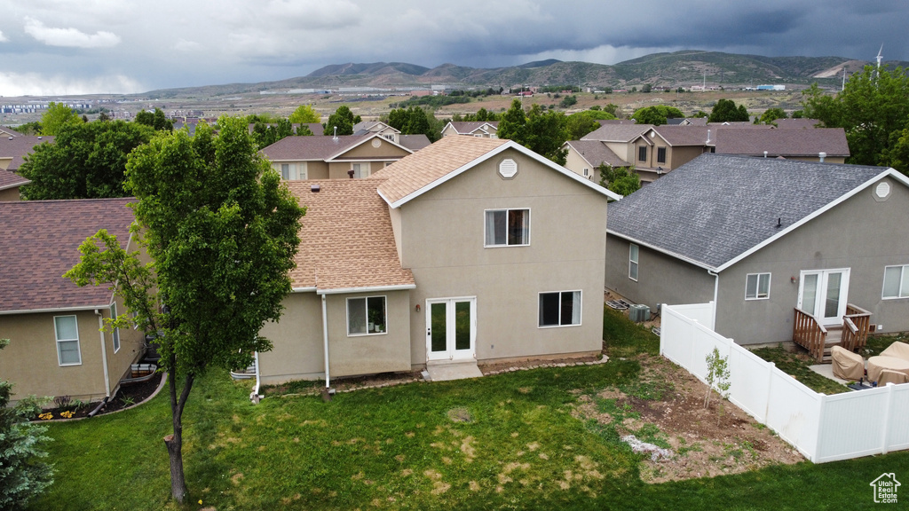 Back of property with french doors, a mountain view, a residential view, and stucco siding