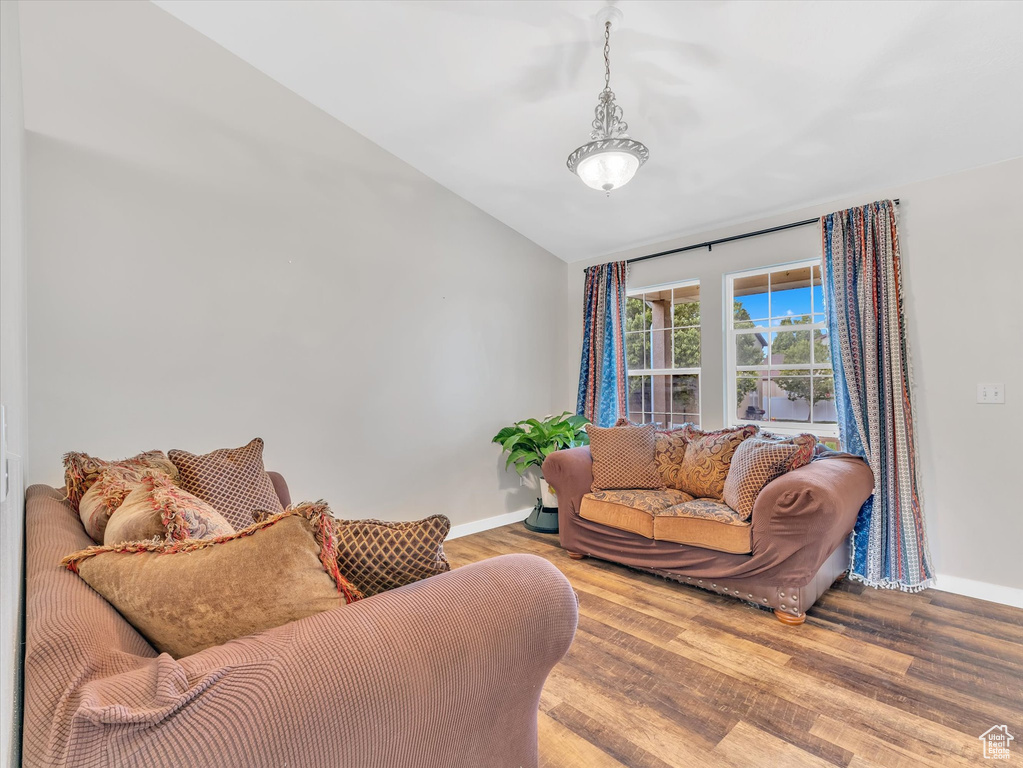 Living area with lofted ceiling, baseboards, and wood finished floors
