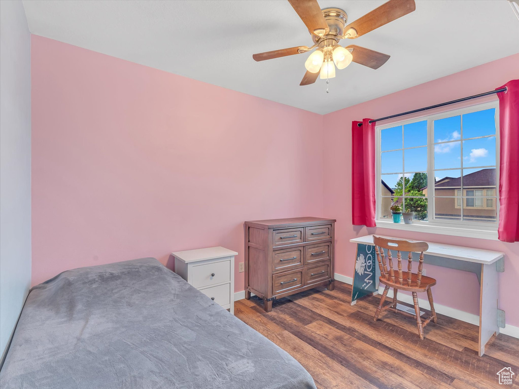 Bedroom with wood finished floors, baseboards, and ceiling fan