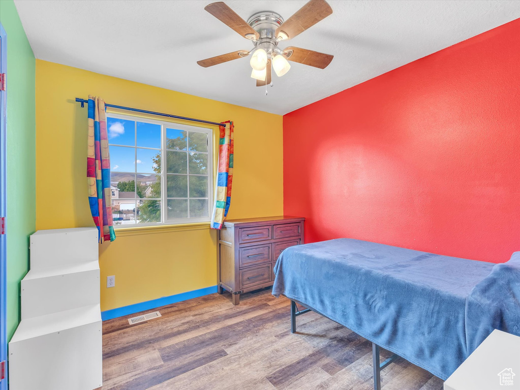 Bedroom featuring wood finished floors, baseboards, and ceiling fan