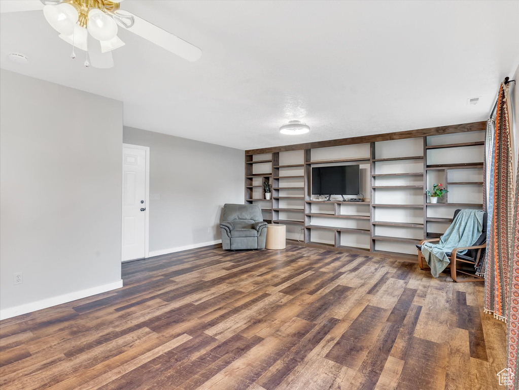 Unfurnished room with ceiling fan, wood finished floors, and baseboards